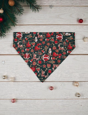 Christmas-themed dog bandana on a wooden surface with decorative elements.